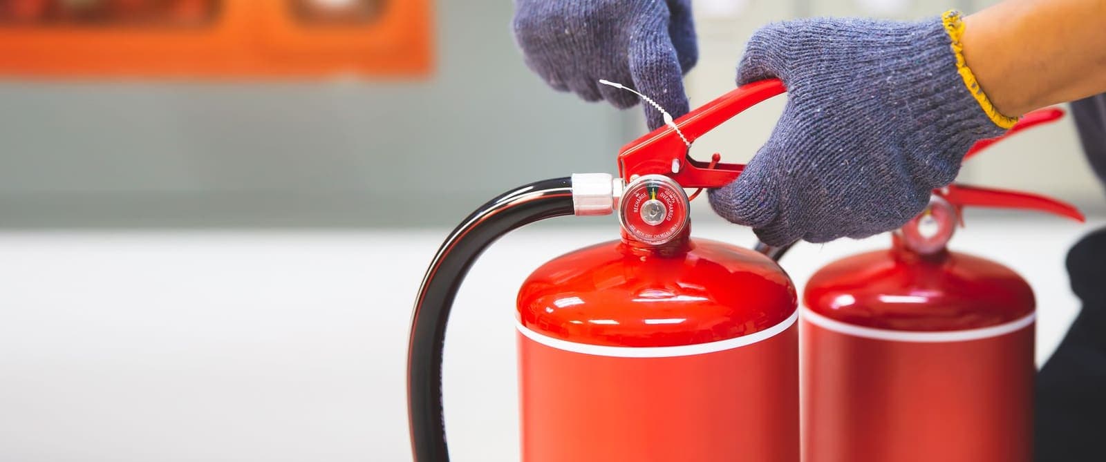 Engineer hand-checking a fire extinguisher during quarterly inspection