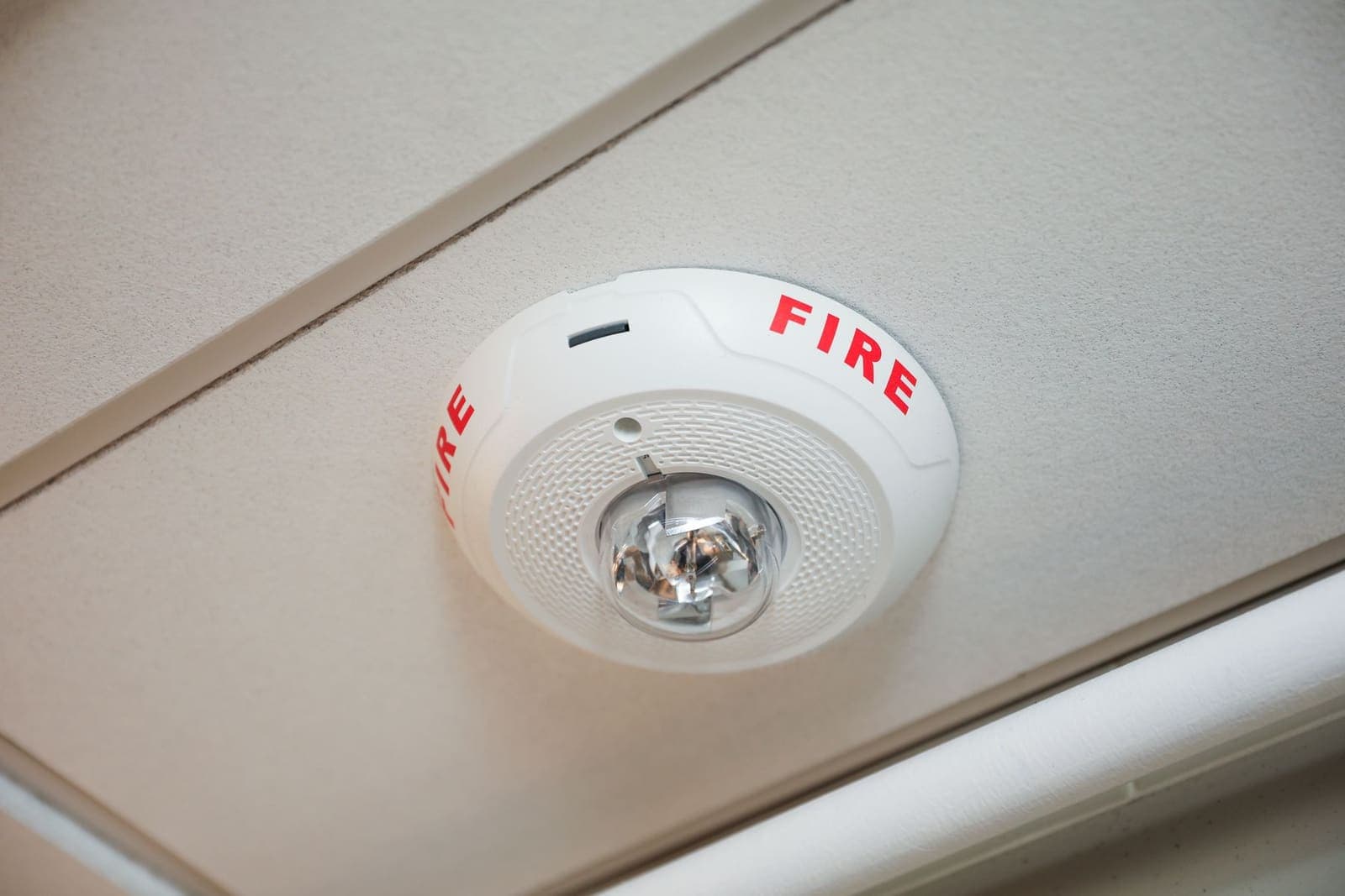 Modern fire alarm control panel with red warning lights inside a building